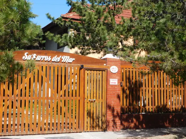 Frente del complejo con cartel Susurros del Mar sobre el portón