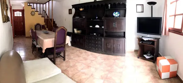 Living comedor con mesa, mueble de madera y escalera a la planta alta
