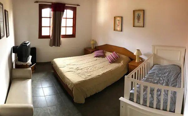 Dormitorio con cama matrimonial y cuna