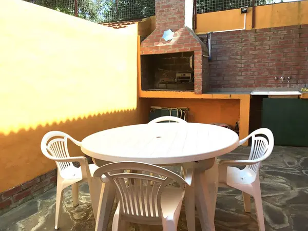 Patio privado con parrilla, mesa y sillas